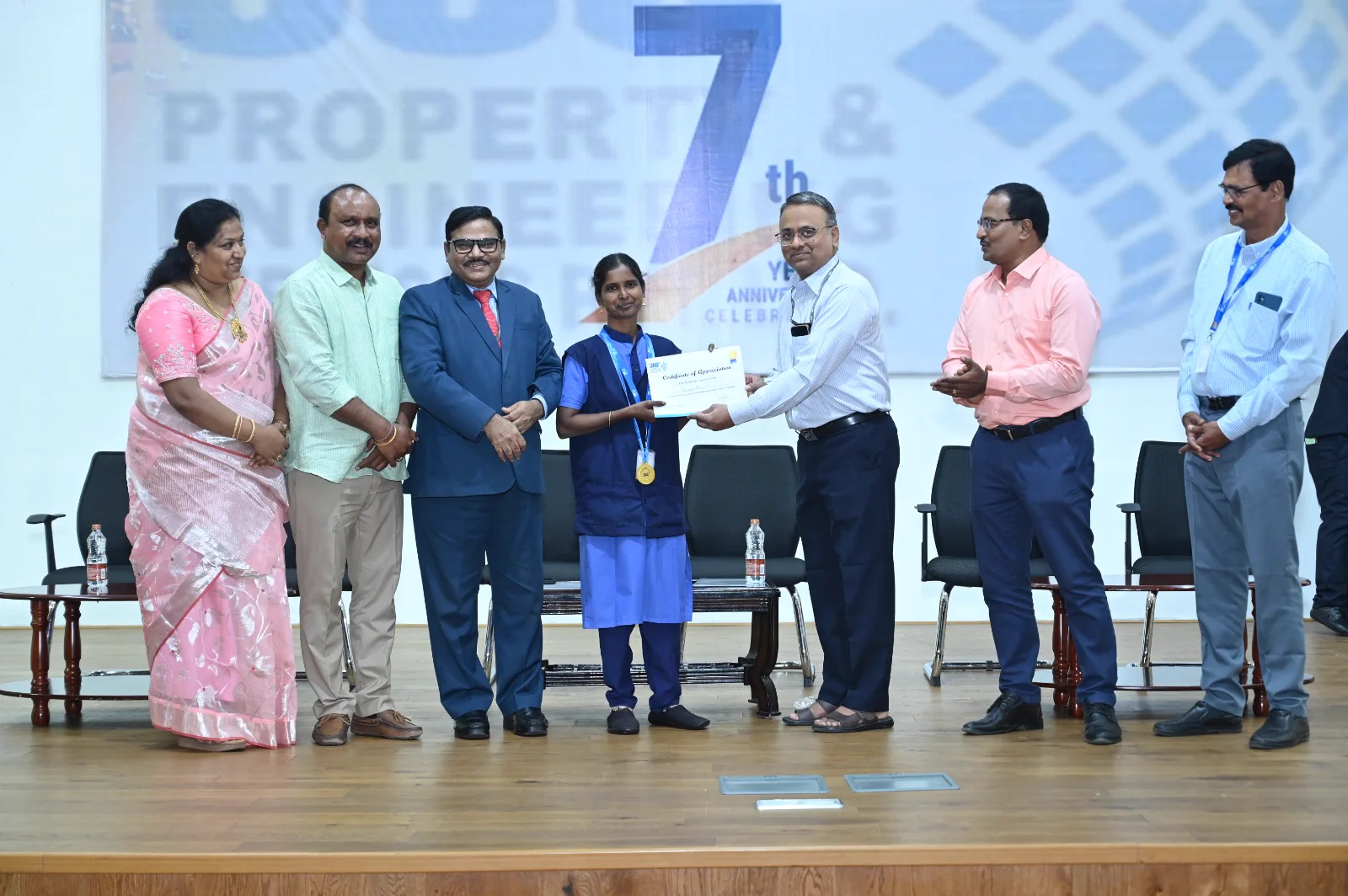 Employee being presented with a certificate and medal at the company recognition event